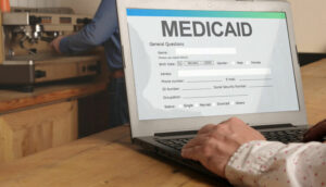 Laptop displaying a Medicaid form, highlighting expanded dental coverage and access to oral health care.